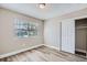 Bright bedroom with wood-look floors, window, and spacious closet at 11335 Pickford St, Spring Hill, FL 34609