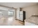 Kitchen with stainless steel refrigerator, granite countertops, and light wood flooring at 11335 Pickford St, Spring Hill, FL 34609