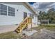 Rear view of the home showcasing stairs and deck at 11335 Pickford St, Spring Hill, FL 34609