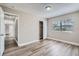 Well-lit bedroom with wood-look floors and an open door to hallway at 11335 Pickford St, Spring Hill, FL 34609