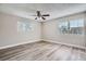 Spacious bedroom with hardwood floors, ceiling fan, and large windows at 11335 Pickford St, Spring Hill, FL 34609