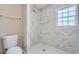 Bathroom with marble shower, toilet and white hexagonal floor tiles at 11335 Pickford St, Spring Hill, FL 34609