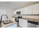 Modern kitchen with white cabinets, granite counters, and stainless steel appliances at 11335 Pickford St, Spring Hill, FL 34609