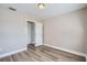 Light and airy bedroom with wood-look floors and access to a hallway at 11335 Pickford St, Spring Hill, FL 34609