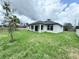 Backyard view with the covered lanai, lawn, and partially fenced yard at 4683 Boston Ter, North Port, FL 34288