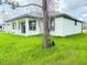 Image of the back of the house with a covered patio and lush green grass at 4683 Boston Ter, North Port, FL 34288