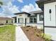 Close-up of a modern home exterior with a beautifully landscaped front yard and a paver walkway at 4683 Boston Ter, North Port, FL 34288