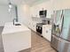 Spacious kitchen featuring a large island, stainless steel appliances, and white cabinets at 4683 Boston Ter, North Port, FL 34288