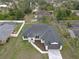 Aerial view of charming new construction featuring a paver driveway and a well manicured lawn at 1081 Mccrory St, North Port, FL 34286