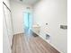 Clean white laundry room featuring a utility sink and laminate floors at 1081 Mccrory St, North Port, FL 34286