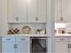 Stylish bar area with white cabinets, a wine rack, and a beverage refrigerator at 19293 Breynia Dr, Lutz, FL 33558