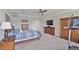 Spacious bedroom with a king bed, tv, and natural wood furniture set at 19293 Breynia Dr, Lutz, FL 33558