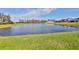 Scenic view of the community pond with a well-manicured lawn and clear blue skies at 19293 Breynia Dr, Lutz, FL 33558