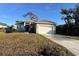 Newly built home with a gray exterior, driveway, and grassy lawn at 217 Antilla Dr, Rotonda West, FL 33947