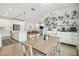 Open concept dining area with light wood table and white kitchen cabinetry at 307 Shore Crab Way, Apollo Beach, FL 33572