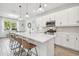 Modern kitchen with white cabinets, island, and stainless steel appliances at 307 Shore Crab Way, Apollo Beach, FL 33572