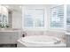 Spa-like bathroom with soaking tub, double vanity, and large window at 340 S Palm Ave # 11, Sarasota, FL 34236