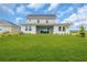 Spacious backyard featuring a well-manicured lawn and the home's rear facade with large windows and sliding glass doors at 2626 Wise River Lane, Zephyrhills, FL 33539
