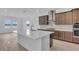 Gourmet kitchen featuring a large island, stainless steel appliances, and custom cabinets and adjacent dining area at 2626 Wise River Lane, Zephyrhills, FL 33539