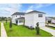 White two-story house with a detached garage and grassy yard at 3611 Lajuana Blvd, Wesley Chapel, FL 33543