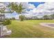 Backyard of residential villa on a golf course with green grass and trees at 13619 Twin Lakes Ln # 15, Tampa, FL 33618