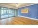 Bedroom features hardwood floors, a sliding glass door to a sunroom, and blue painted walls at 13619 Twin Lakes Ln # 15, Tampa, FL 33618