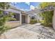 Well-maintained front exterior with a decorative pergola, lush greenery, and inviting entryway at 13619 Twin Lakes Ln # 15, Tampa, FL 33618