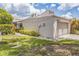 Villa featuring a one car garage with white door, green lawn and bushes at 13619 Twin Lakes Ln # 15, Tampa, FL 33618