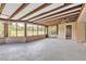Enclosed patio featuring ceiling beams, large windows, and view of an outdoor green space at 13619 Twin Lakes Ln # 15, Tampa, FL 33618