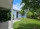 Side view of a light blue house with a covered patio and green lawn at 5400 Circle Dr, Weeki Wachee, FL 34607