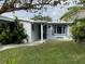 Single-story home with a blue door and a nicely landscaped yard at 5400 Circle Dr, Weeki Wachee, FL 34607