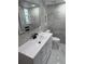 Updated bathroom with gray tile, white vanity, and modern fixtures at 1007 Normandy Rd, Clearwater, FL 33764