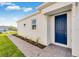 Bright white home with a vibrant blue front door and neatly landscaped walkway at 16111 Ivy Ridge Ct, Port Charlotte, FL 33953