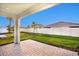 A paver patio looks out over a fenced yard and blue sky at 16126 Ivy Ridge Ct, Port Charlotte, FL 33953