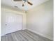 Bedroom with wood-look floors, ceiling fan, and double door closet at 2771 Whispering Pine Ln, North Port, FL 34287