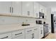 Modern kitchen with white cabinets, quartz countertops and black hardware at 14038 Cooper Rd, Spring Hill, FL 34609