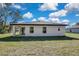 Home's back exterior with grassy yard at 8319 Begonia St, Spring Hill, FL 34608