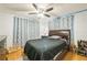 Bedroom with ceiling fan, dark bedding, and patterned curtains at 4536 Brooksdale Dr, Sarasota, FL 34232