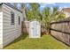 Grey storage shed in backyard with well maintained lawn and fence at 3310 W Marlin Ave, Tampa, FL 33611