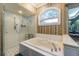 Bathroom with a walk-in shower, soaking tub, and arched window at 5900 98Th N Ave, Pinellas Park, FL 33782