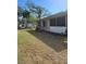 View of home's backyard featuring grass, trees, and back exterior of the home at 21300 Washburn Ave, Port Charlotte, FL 33952