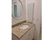 Bathroom featuring a granite countertop, framed mirror, and storage cabinet at 21300 Washburn Ave, Port Charlotte, FL 33952