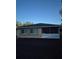 View of home's back exterior featuring screen room, windows, and newly laid dirt at 21300 Washburn Ave, Port Charlotte, FL 33952