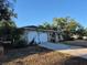 Exterior shot of a single-story home showing a curved driveway, arched door, and stone decor at 21300 Washburn Ave, Port Charlotte, FL 33952