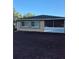 View of home's back exterior featuring screen room, windows, and newly laid dirt at 21300 Washburn Ave, Port Charlotte, FL 33952