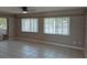 An expansive living room features tile floors, sliding glass doors, and large windows with white blinds at 21300 Washburn Ave, Port Charlotte, FL 33952