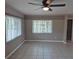 Spacious room featuring tile flooring, two windows, and a ceiling fan at 21300 Washburn Ave, Port Charlotte, FL 33952
