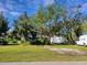 Yard with parked RV, utility trailer, and work van surrounded by mature trees at 21300 Washburn Ave, Port Charlotte, FL 33952
