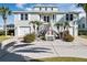 Two-story light green house with a large driveway, landscaping, and palm trees at 4049 Cobia Dr, Hernando Beach, FL 34607