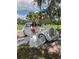 Bride in wedding dress posing next to a vintage white car at 15625 State Road 62 St, Parrish, FL 34219